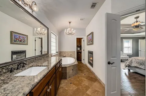 a spacious bathroom with a granite countertop sink and a large mirror