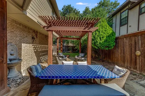 a view of a patio with table and chairs with wooden floor and fence