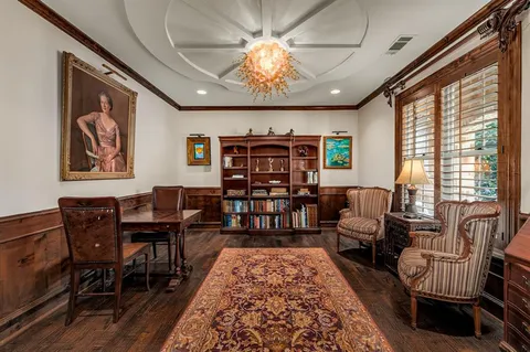 a living room with furniture a piano and a bookshelf