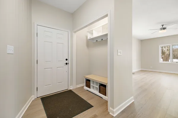 an entryway with wooden floor and cabinet