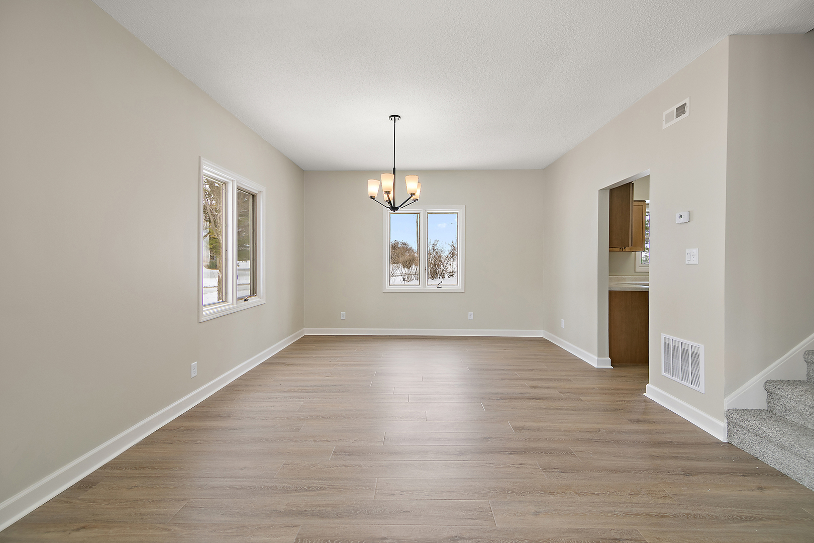 101 Sun Street, Unit A Cabery, IL 60919 - Photo 7 of 26 an empty room with wooden floor chandelier and windows