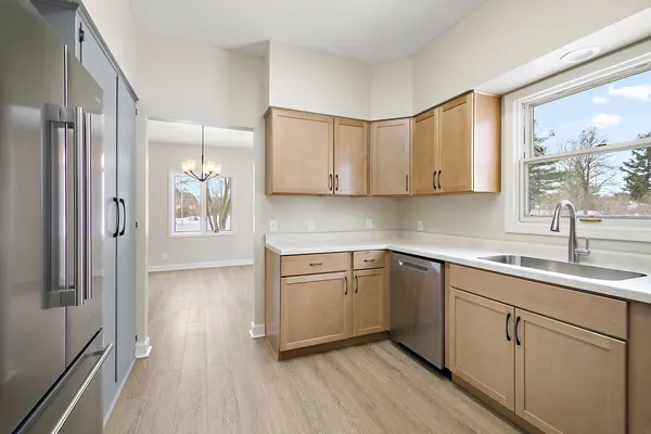 a kitchen with a sink cabinets stainless steel appliances and a window