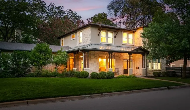 a front view of a house with a garden and trees