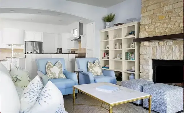 a living room with furniture a fireplace and a floor to ceiling window