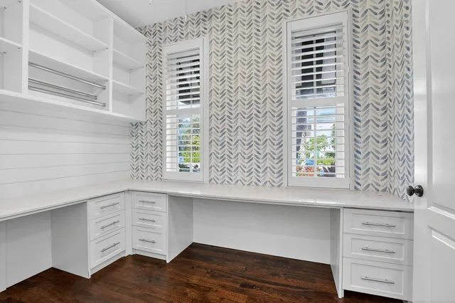 a view of an empty room with wooden floor and stairs
