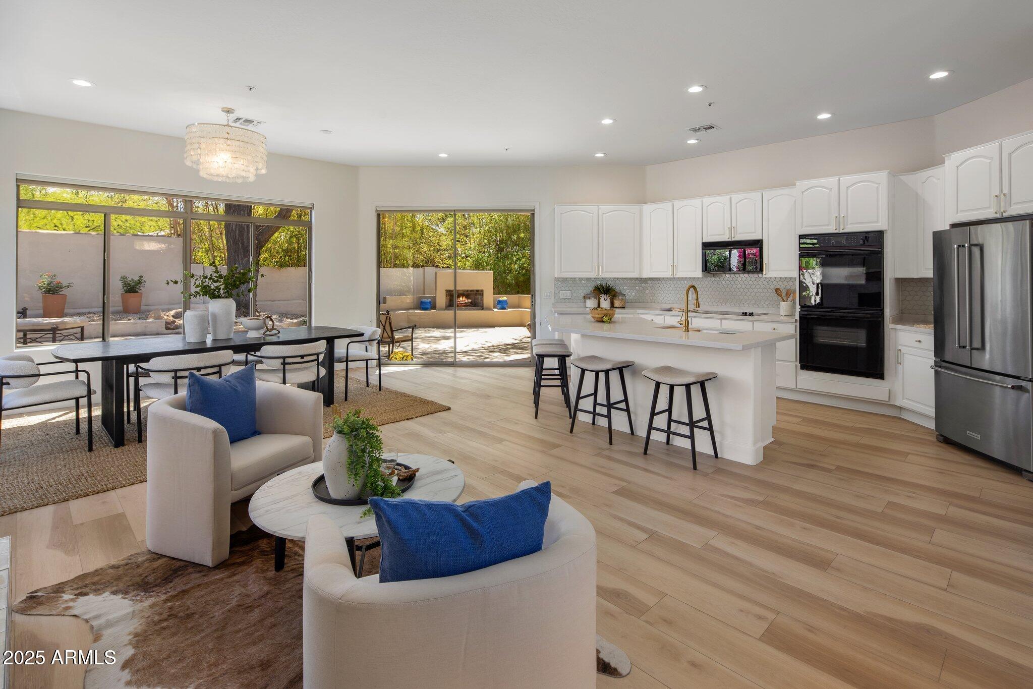 8227 East Beardsley Road Scottsdale, AZ 85255 - Photo 3 of 20 a living room with stainless steel appliances kitchen island granite countertop a table chairs and a living room