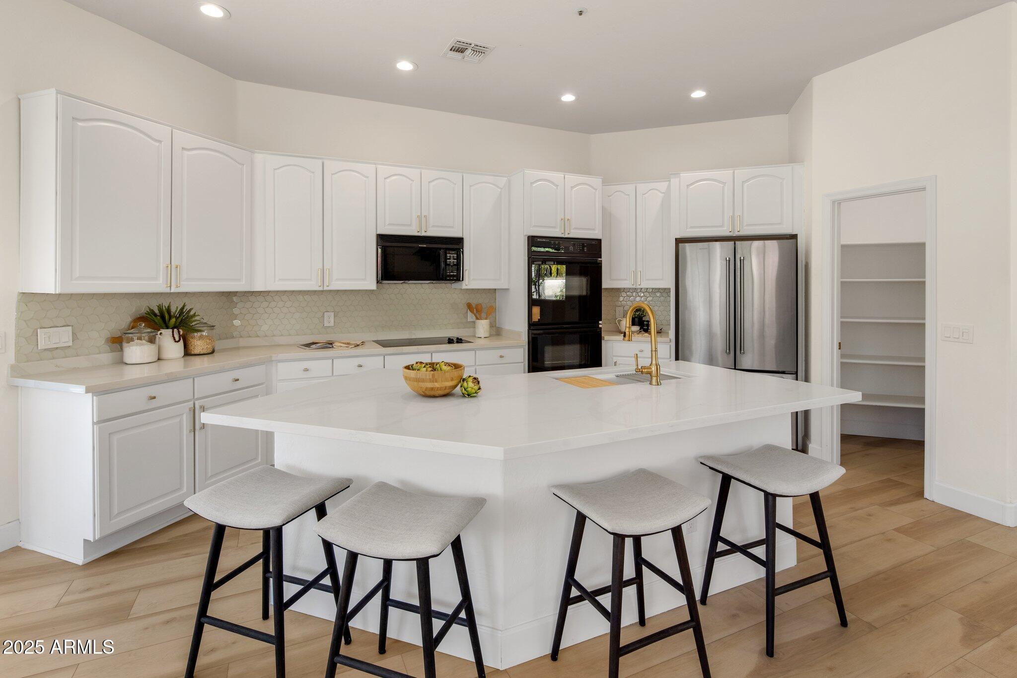 8227 East Beardsley Road Scottsdale, AZ 85255 - Photo 9 of 20 a kitchen with stainless steel appliances a refrigerator and a stove top oven
