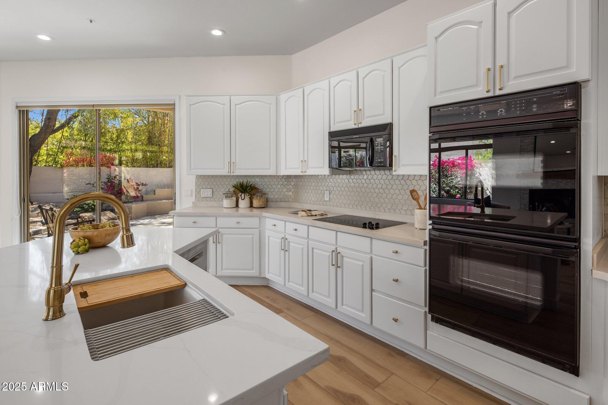 8227 East Beardsley Road Scottsdale, AZ 85255 - Photo 10 of 20 a kitchen with granite countertop a stove sink and cabinets