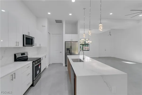 a kitchen with kitchen island a sink stainless steel appliances and counter space