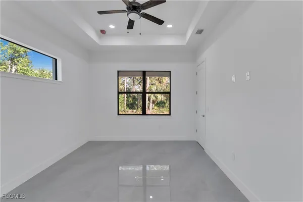 an empty room with window and ceiling fan