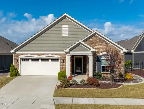 a view of a white house with large windows and plants