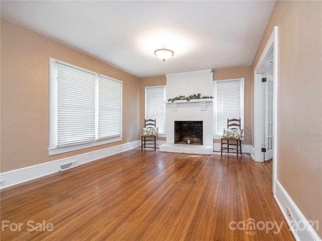 3514 Kelly Road Charlotte, NC 28216 - Photo 12 of 34 an empty room with wooden floor fireplace and windows