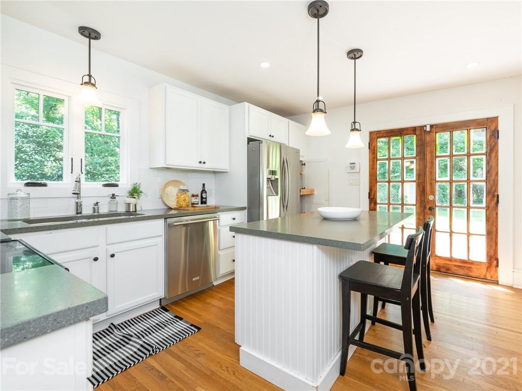 3514 Kelly Road Charlotte, NC 28216 - Photo 13 of 34 a kitchen with stainless steel appliances granite countertop a stove top oven a sink dishwasher a dining table and chairs with wooden floor