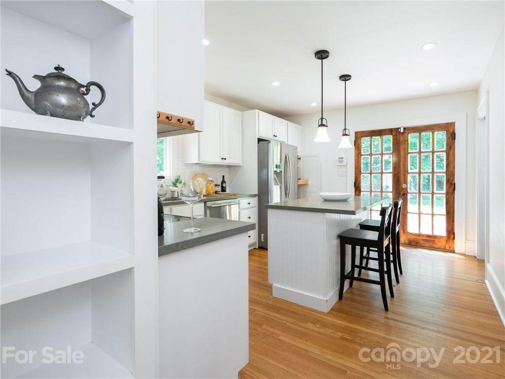 3514 Kelly Road Charlotte, NC 28216 - Photo 15 of 34 a kitchen with stainless steel appliances granite countertop a white table chairs and a wooden floor