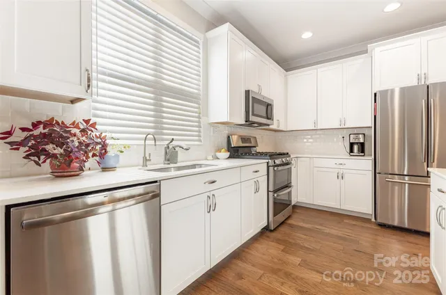a kitchen with white cabinets and white appliances