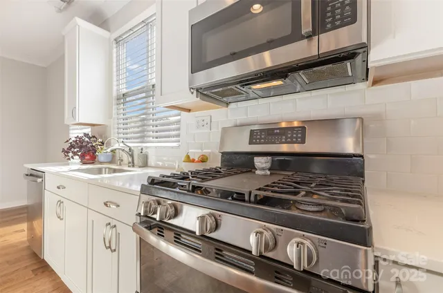 a kitchen with granite countertop stainless steel appliances and white cabinets