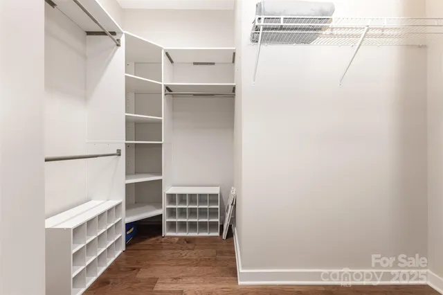 a view of walk in closet with empty racks