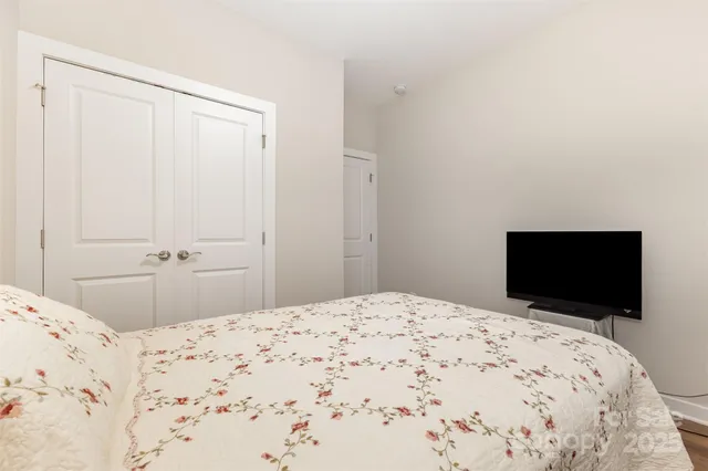 a bedroom with a bed and a flat screen tv