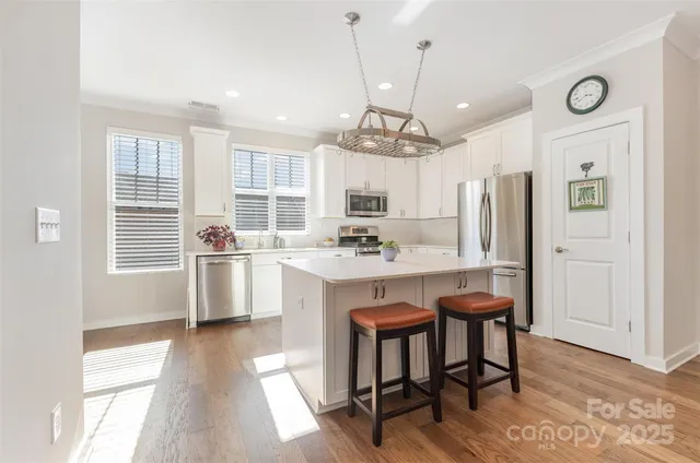 a kitchen with granite countertop a sink cabinets stainless steel appliances and a window