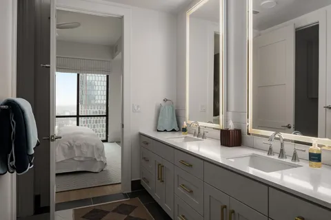 a en suite bathroom with a double vanity sink and mirror