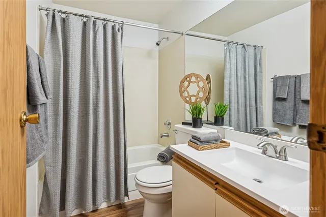 a bathroom with a granite countertop sink a toilet and a shower curtain