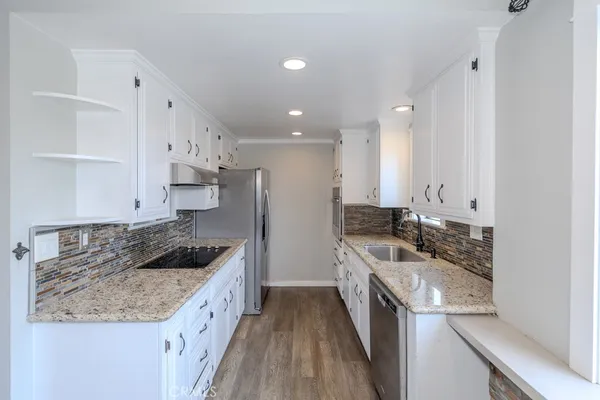 a kitchen with a sink stove top oven and refrigerator