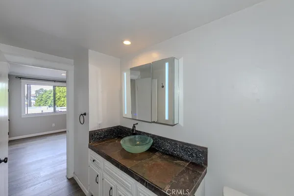 a bathroom with a granite countertop sink and a mirror