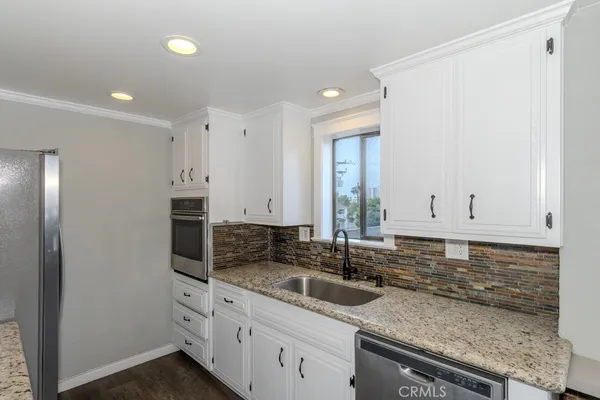 a kitchen with stainless steel appliances granite countertop a sink stove and cabinets