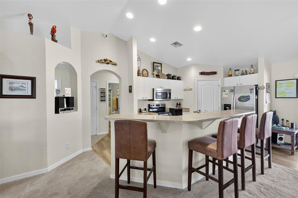 125 Paddock Street Lehigh Acres, FL 33974 - Photo 11 of 45 a dining room with stainless steel appliances furniture a window and a kitchen view