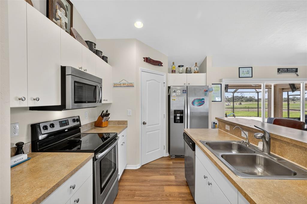 125 Paddock Street Lehigh Acres, FL 33974 - Photo 12 of 45 a kitchen with stainless steel appliances granite countertop a sink stove and refrigerator