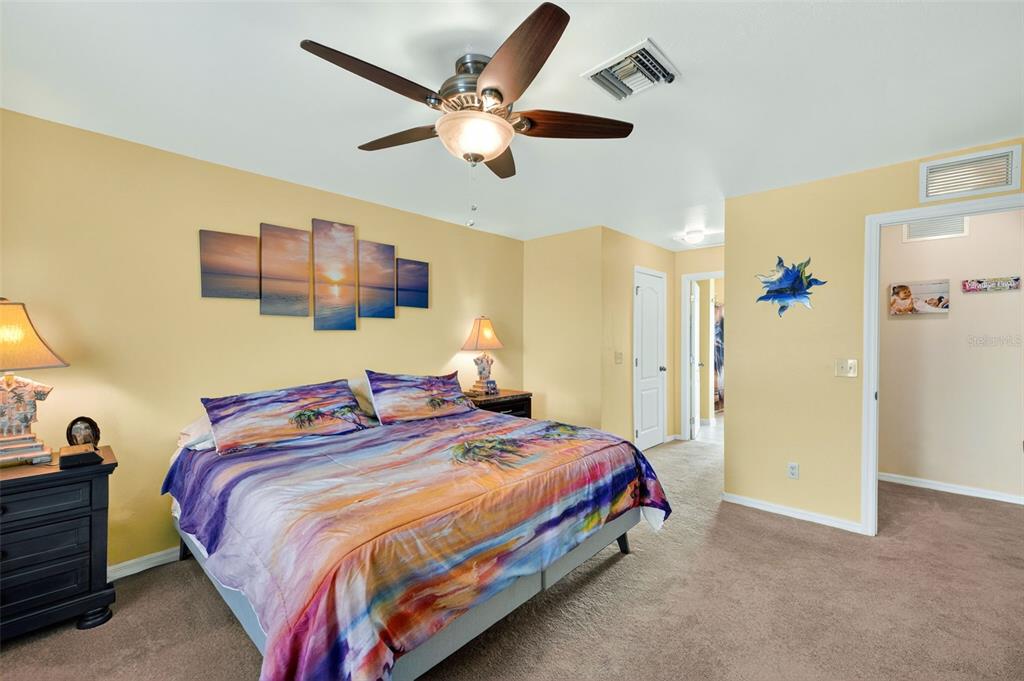 125 Paddock Street Lehigh Acres, FL 33974 - Photo 16 of 45 a bedroom with a bed and a chandelier
