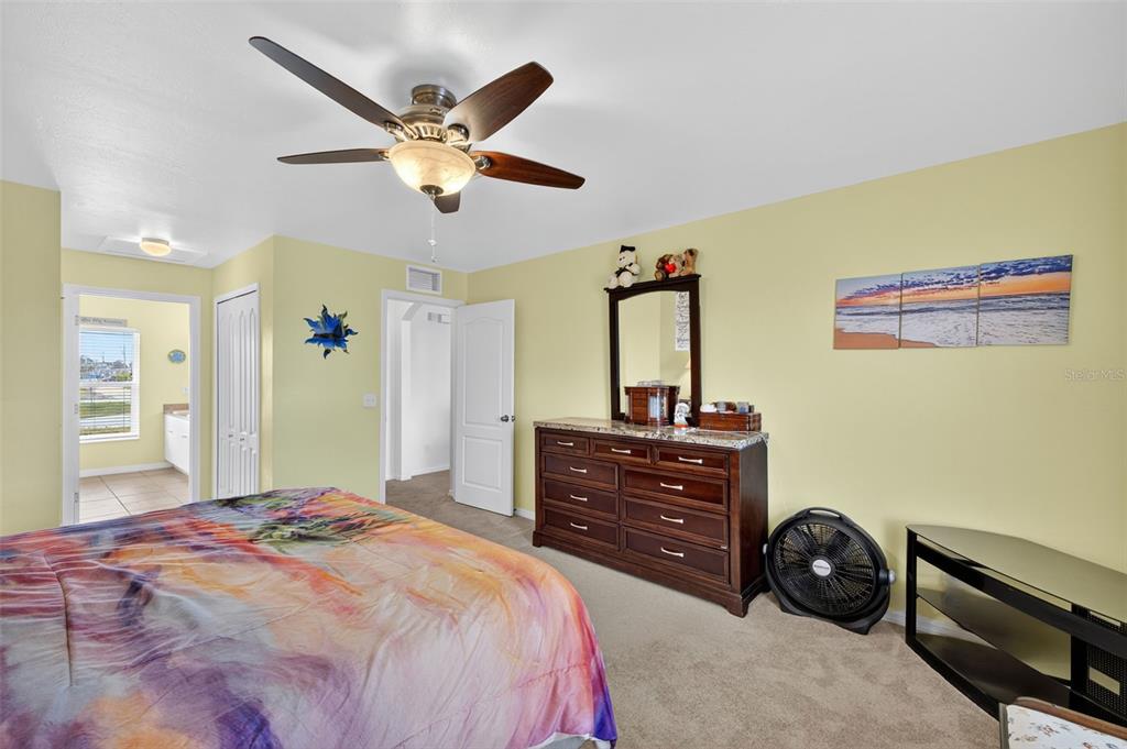 125 Paddock Street Lehigh Acres, FL 33974 - Photo 17 of 45 a bedroom with a bed and a chandelier