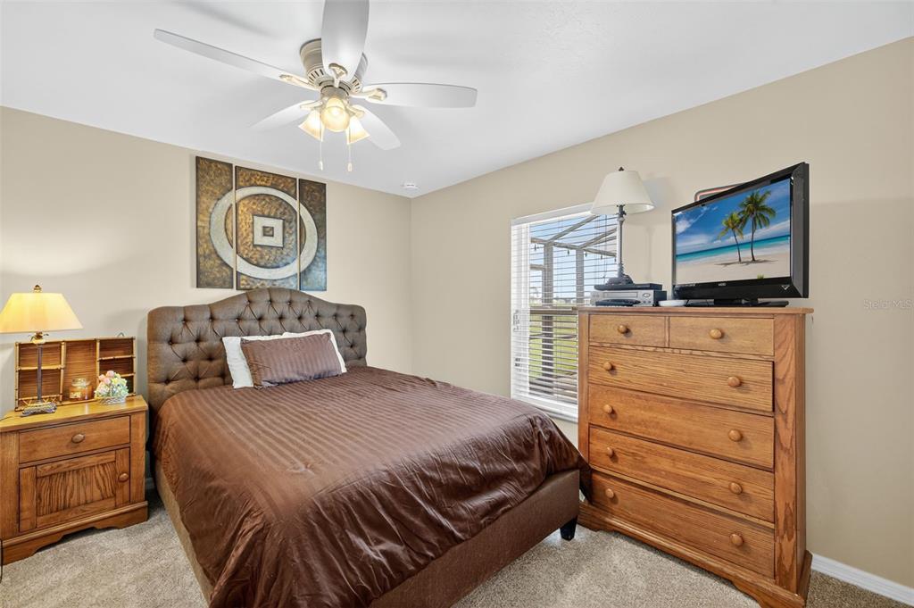 125 Paddock Street Lehigh Acres, FL 33974 - Photo 21 of 45 a bedroom with a bed and a chandelier