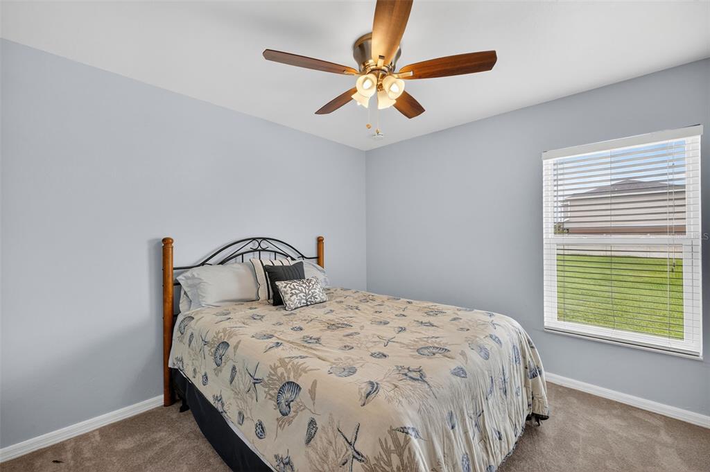 125 Paddock Street Lehigh Acres, FL 33974 - Photo 23 of 45 a bedroom with a large bed and a large window