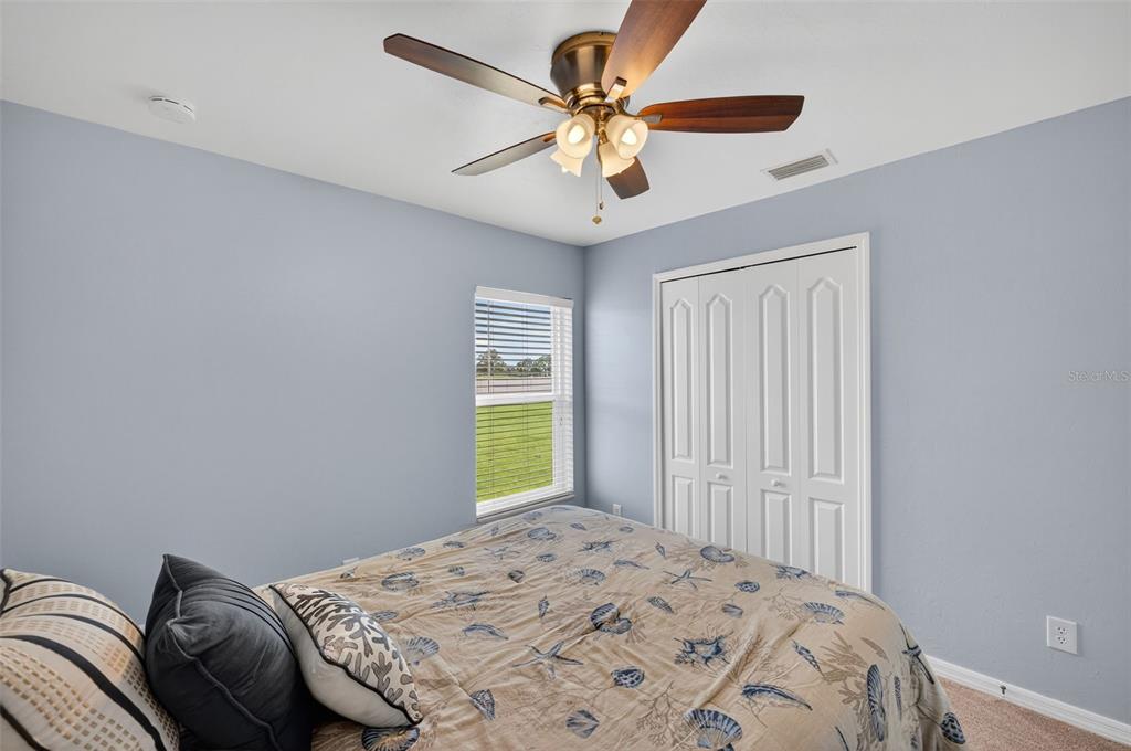 125 Paddock Street Lehigh Acres, FL 33974 - Photo 24 of 45 a bedroom with a bed and a chandelier