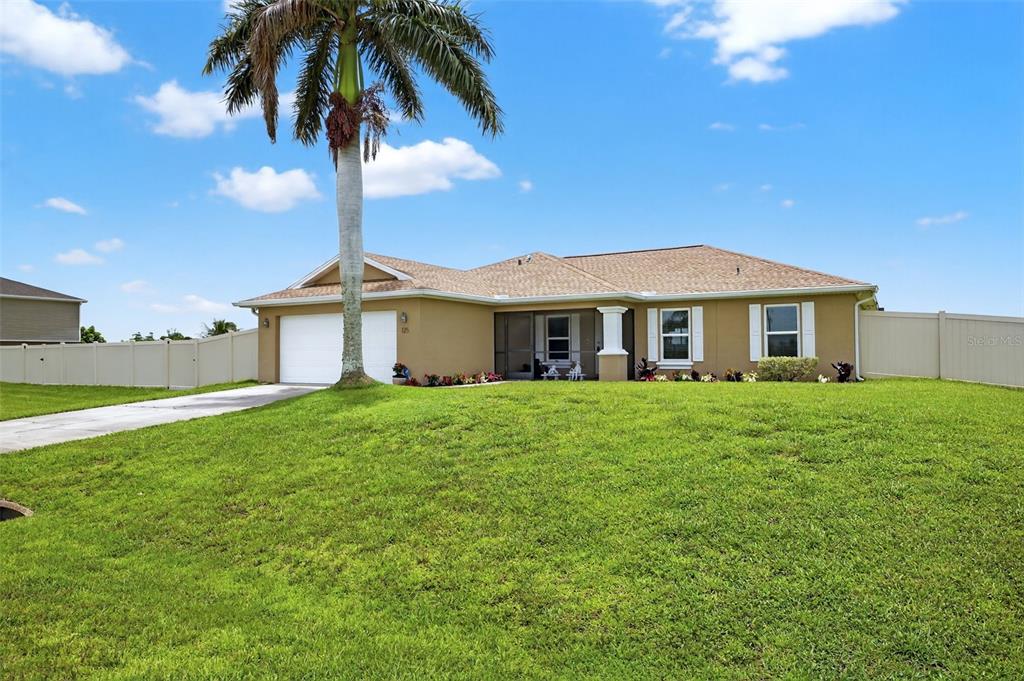 125 Paddock Street Lehigh Acres, FL 33974 - Photo 3 of 45 a front view of a house with a garden