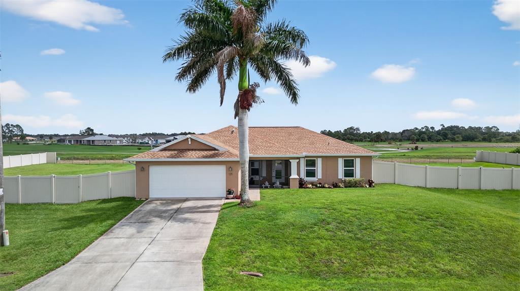 125 Paddock Street Lehigh Acres, FL 33974 - Photo 35 of 45 a front view of a house with a garden and yard