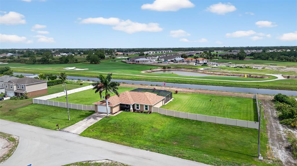 125 Paddock Street Lehigh Acres, FL 33974 - Photo 36 of 45 an aerial view of a golf course with a big yard