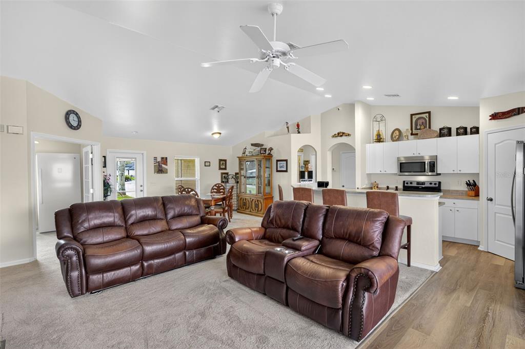 125 Paddock Street Lehigh Acres, FL 33974 - Photo 9 of 45 a living room with furniture kitchen view and a chandelier