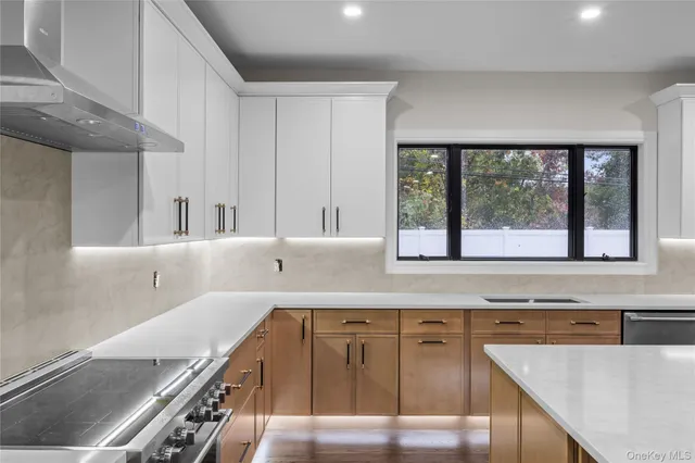 a kitchen with a stove a sink and a granite counter tops