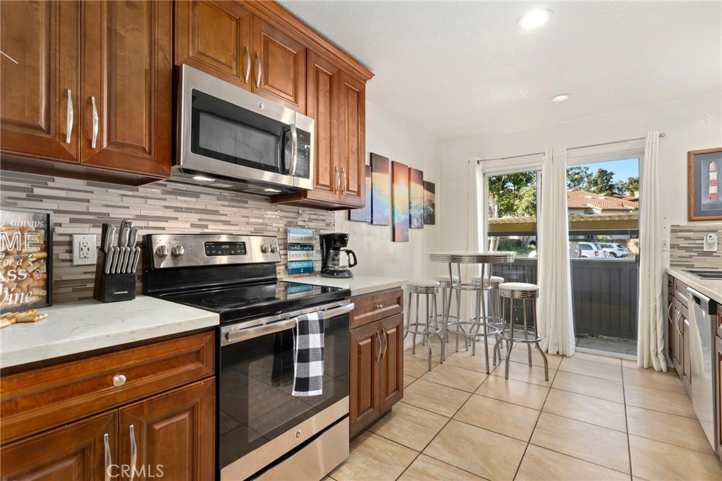 14 Corniche Drive, Unit A Dana Point, CA 92629 - Photo 11 of 49 a kitchen with stainless steel appliances granite countertop a stove top oven a sink dishwasher and a microwave oven on the blue kitchen countertops