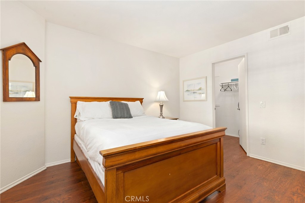 14 Corniche Drive, Unit A Dana Point, CA 92629 - Photo 21 of 49 a bed sitting in a bedroom next to a window with wooden floor