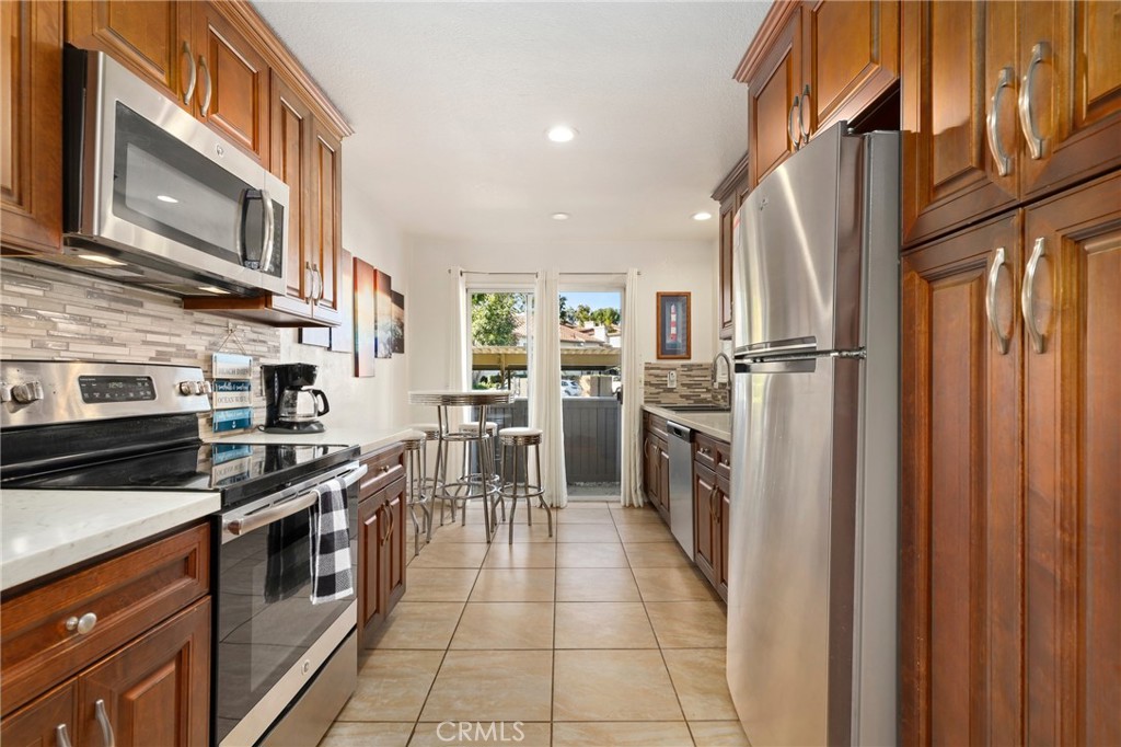 14 Corniche Drive, Unit A Dana Point, CA 92629 - Photo 9 of 49 a kitchen with stainless steel appliances granite countertop a stove top oven a sink and a refrigerator
