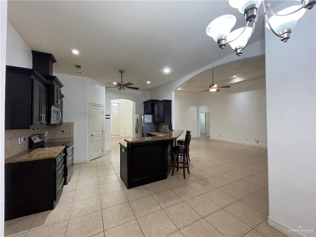 a kitchen with stainless steel appliances kitchen island granite countertop a sink and cabinets
