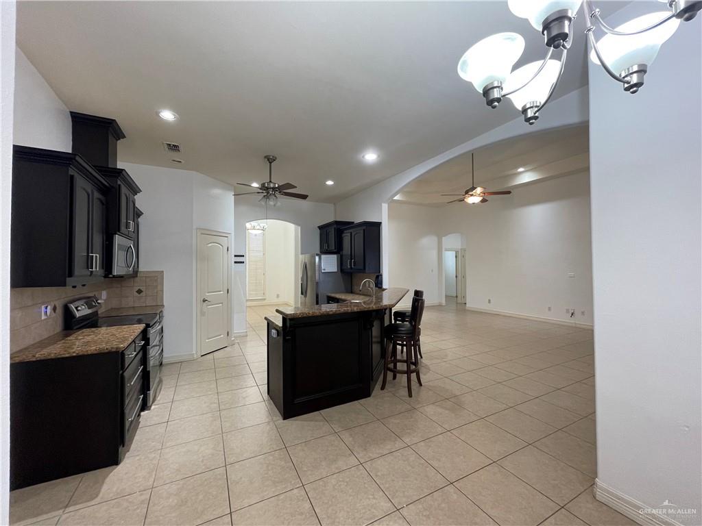 1000 South Flag Street Pharr, TX 78577 - Photo 11 of 24 a kitchen with stainless steel appliances kitchen island granite countertop a sink and cabinets