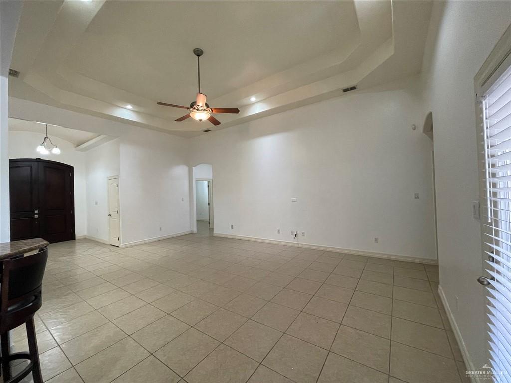 1000 South Flag Street Pharr, TX 78577 - Photo 13 of 24 an empty room with chandelier fan and windows