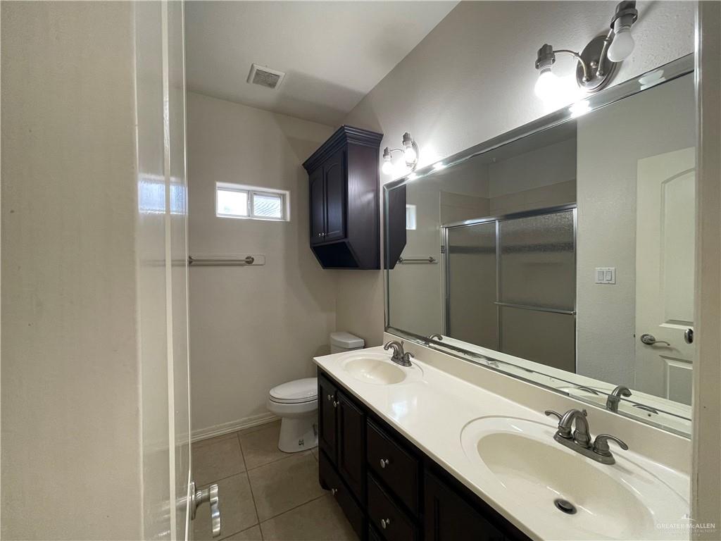 1000 South Flag Street Pharr, TX 78577 - Photo 16 of 24 a bathroom with a double vanity sink toilet and mirror