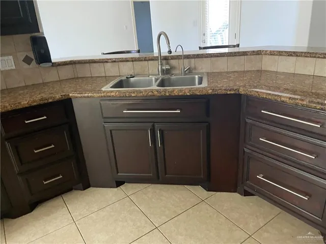 a kitchen with granite countertop a sink and a stove
