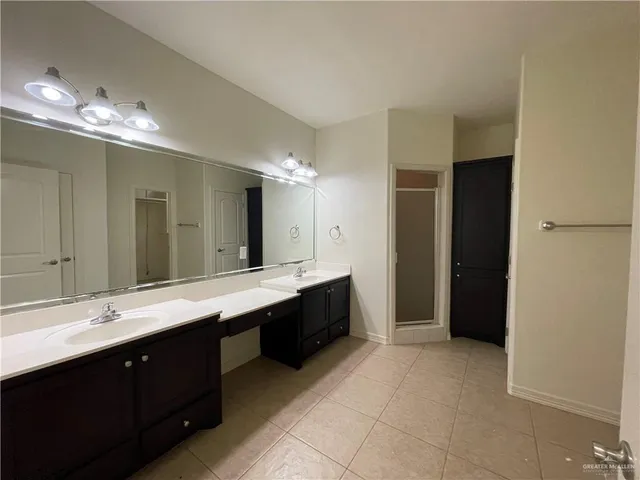 a spacious bathroom with a double vanity sink and a mirror