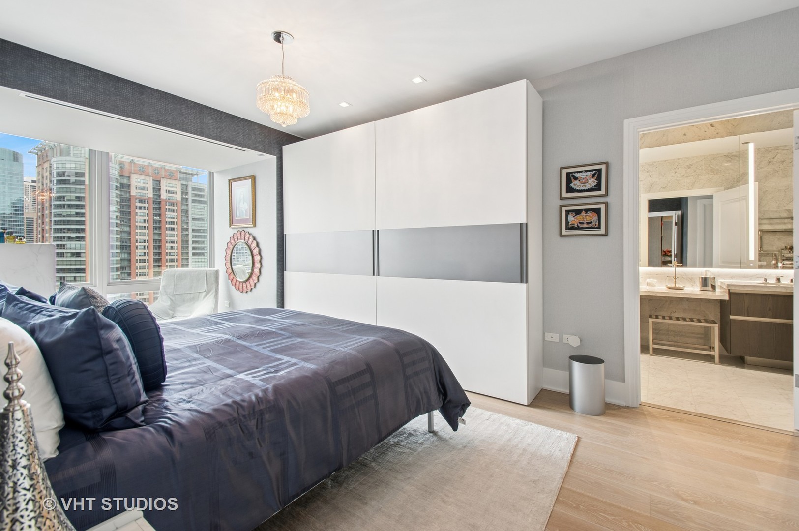363 East Wacker Drive, Unit 1302 Chicago, IL 60601 - Photo 13 of 31 a bedroom with a large bed and a chandelier